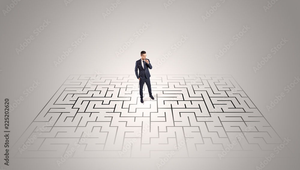 Elegant businessman looking for a solution in a middle of a maze
Elegant businessman looking for a solution in a middle of a maze