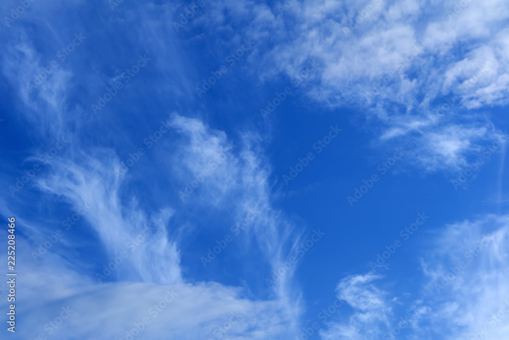 celestial background - blue day sky with white cirro-cumulus clouds..