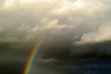 rainbow against the gray clouds of stormy sky