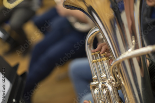 A person playing a silver plated tuba in rehearsal