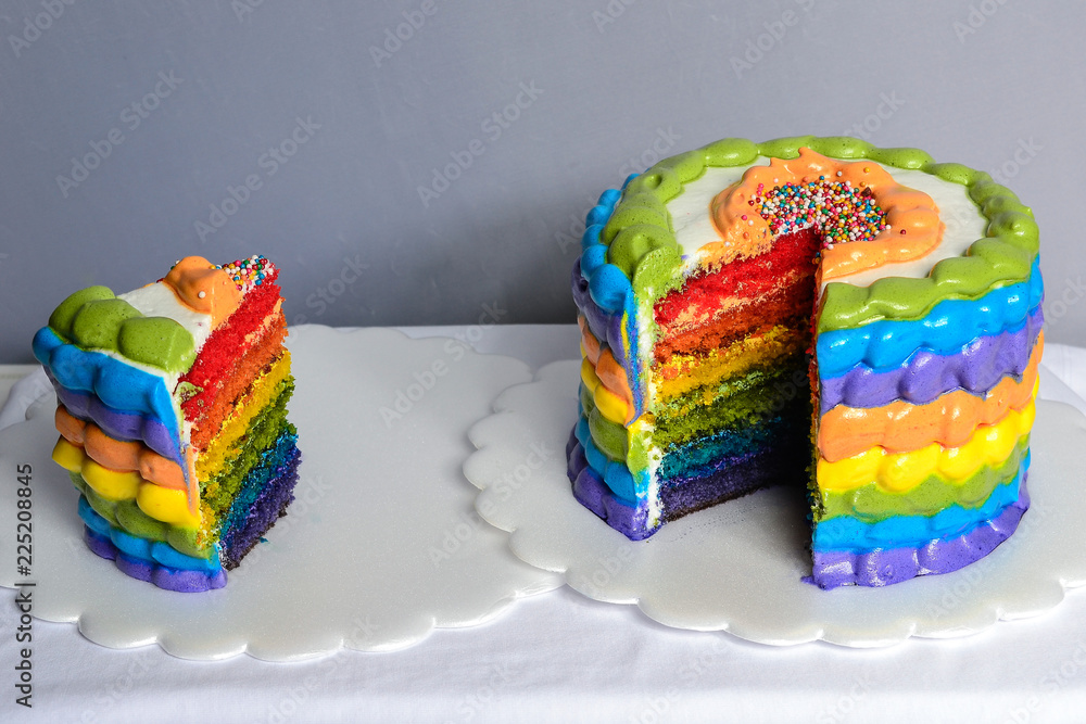 birthday cake with the colors of the rainbow with a piece Stock Photo