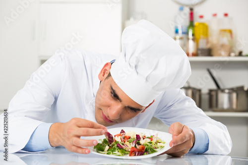 Young male is evaluating prepared dish