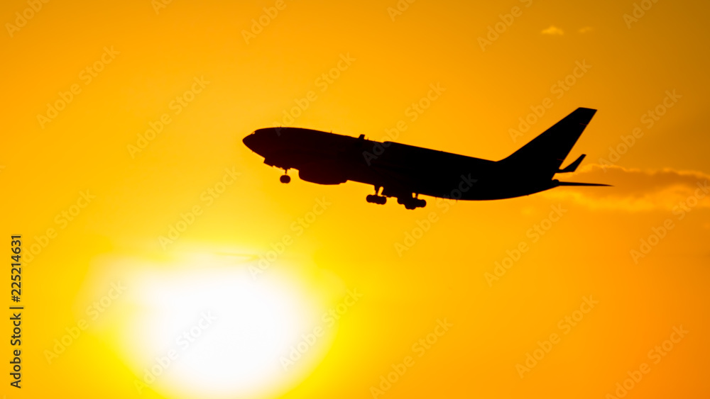 A flying airliner in the evening sky - a contour photography in the backlight. Contre-jour is a photographic technique in which the camera is pointing directly toward a source of light. A flying airliner in the evening sky - a contour photography in the backlight. Contre-jour is a photographic technique in which the camera is pointing directly toward a source of light.