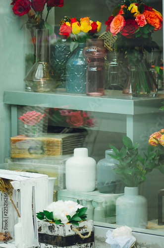 Beautifully designed storefront, flowers and glass vessels. Vintage style, vertical photography.