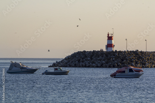 Boats on the sea and red lighthouse