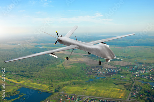 Unmanned military drone on patrol air territory at low altitude.