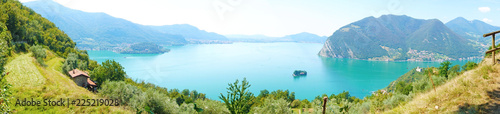 Panoramic view of mountain lake with island in the middle. Panorama from Monte Isola Island with Lake Iseo. Italian landscape. Island on lake. View from the island Monte Isola on Lake Iseo, Italy.