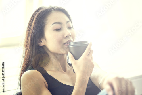 Young asian woman holding a cup of coffee, smell good and enjoy the coffee. lady lady girl. Street style.
