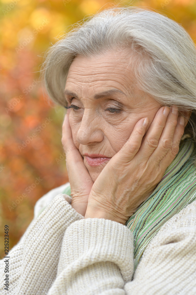 Portrait of sad senior woman in autumn park Portrait of sad senior woman in autumn park