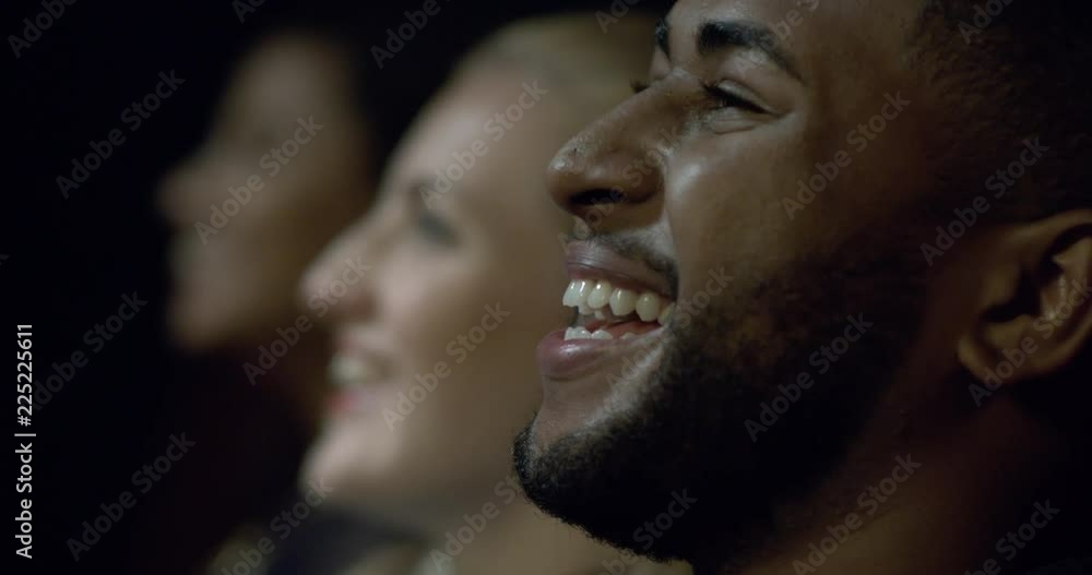 Extreme close up of a movie theatre audience laughing and enjoying a movie. Extreme close up of a movie theatre audience laughing and enjoying a movie.