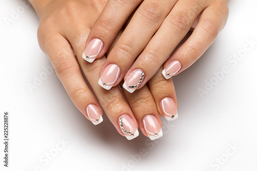 Wedding French manicure with crystals and drawings on long square nails on a white background closeup  