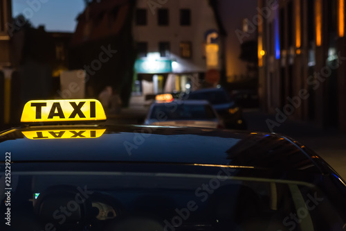 Fototapeta Naklejka Na Ścianę i Meble -  illuminated sign taxi on the roof of the car