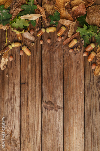 Autumn composition with dry leaves and ripe pumpkins on a wooden table. Top view. Copy space