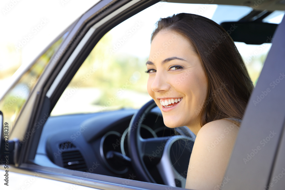 Happy driver looking at you inside a car