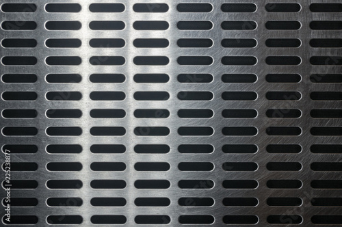 stainless steel grating with oblong holes, close up.
