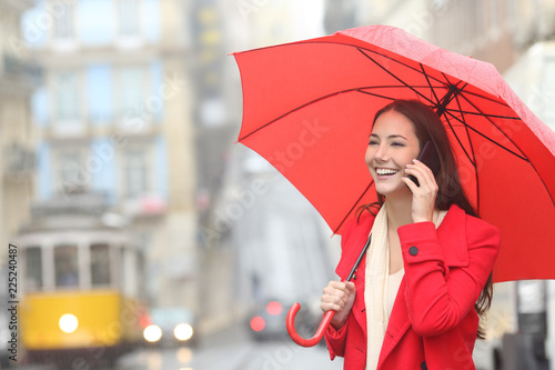 Woman talking on phone under the rain in winter