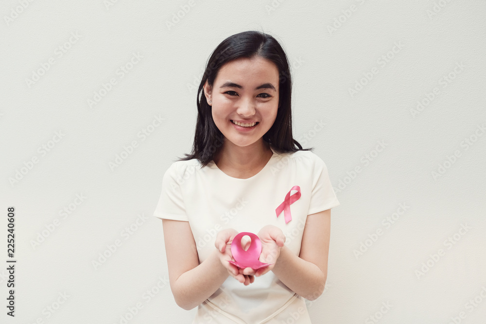 Asian young woman holding pink ribbon, breast cancer awareness, October pink concept Asian young woman holding pink ribbon, breast cancer awareness, October pink concept