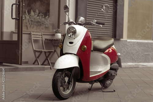 Vintage scooter stands in an alley. Post process in vintage styl