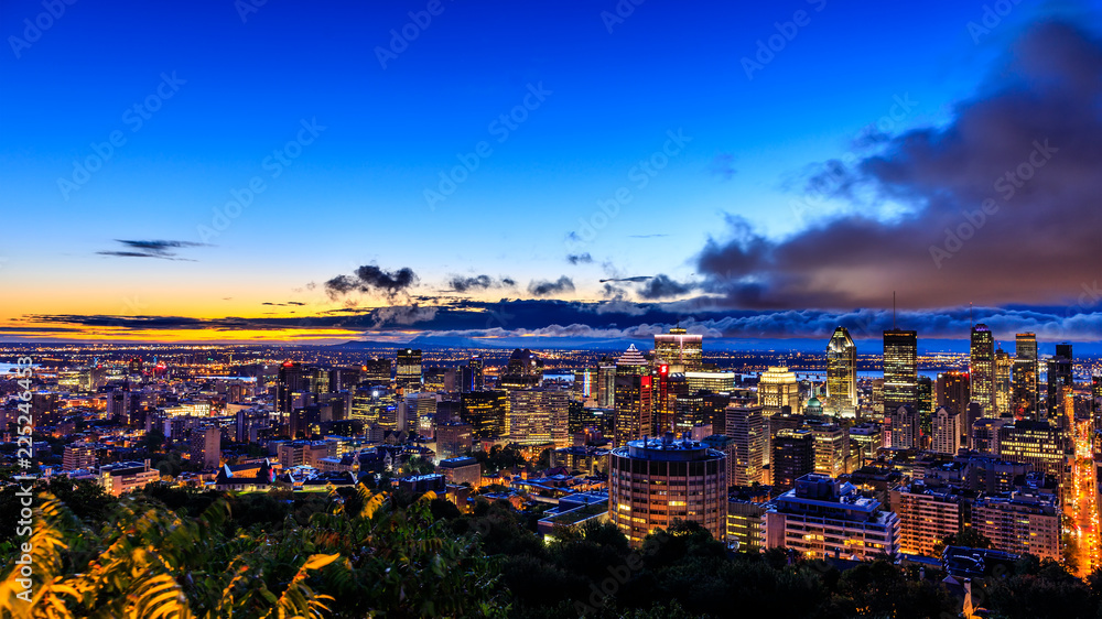 Fototapeta premium Beautiful Montreal at sunrise or sunset. Amazing view from Belvedere with colorful autumn leaves. Stunning panorama of Montreal downtown skyline in the fall night time.