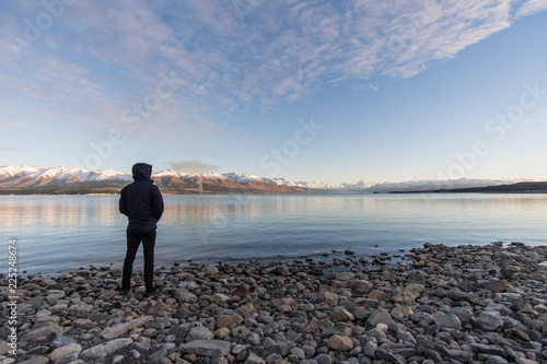 Man standing on rocks looking at Mt Cook, New Zealand