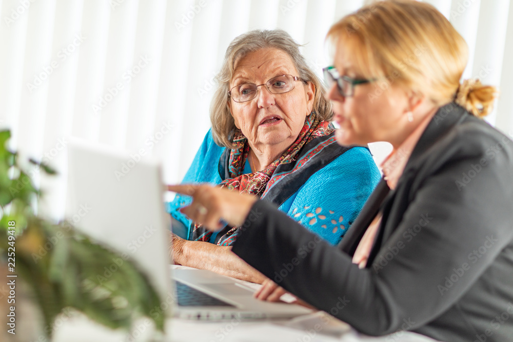 Woman Helping Senior Adult Lady on Laptop Computer Woman Helping Senior Adult Lady on Laptop Computer