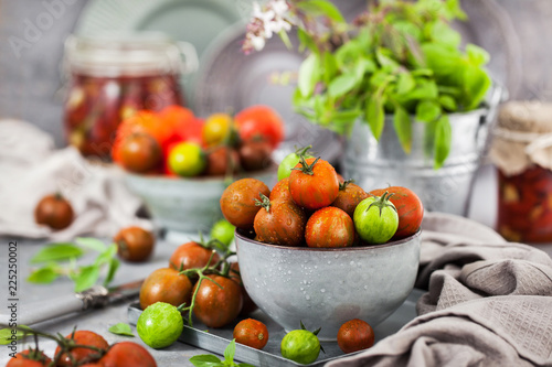 Fresh ripe cherry tomatoes in bowl on gray background