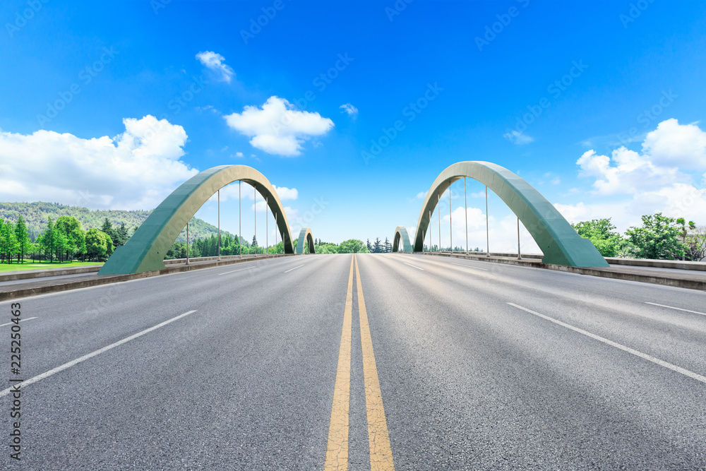 Obraz premium Asphalt highway and green forest natural scenery under the blue sky
