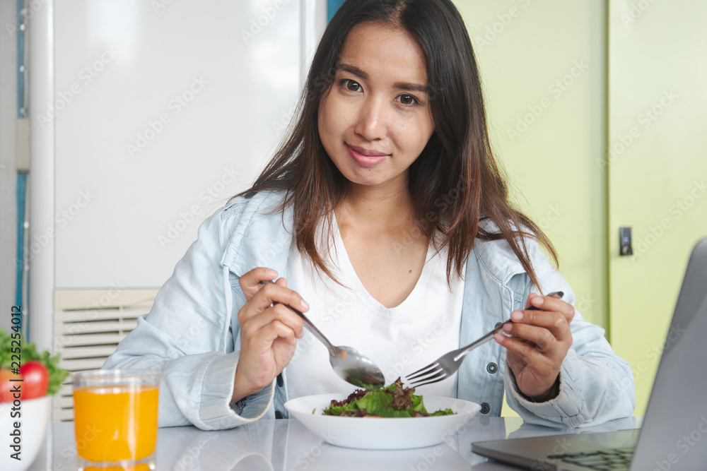 Eating healthy breakfast concept. woman holding dish of salad with variety vegetables and glass of orange juice on the floor in the morning at home. Eating healthy breakfast concept. woman holding dish of salad with variety vegetables and glass of orange juice on the floor in the morning at home.