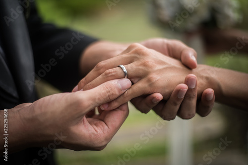 Close up of groom wears the ring bride in wedding day. Love, happy marry concept. © Johnstocker