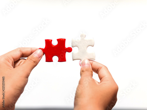 hands holding piece of jigsaw puzzle