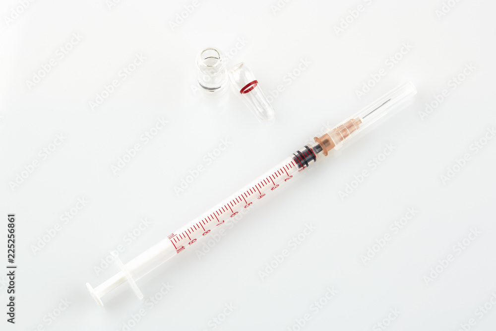 Naklejka premium Ampoule with medicine and syringe on white background