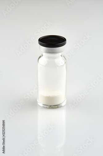 Small sealed bottle with medicine on white background