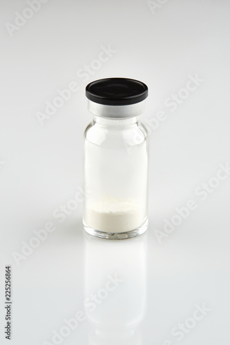 Small sealed bottle with medicine on white background