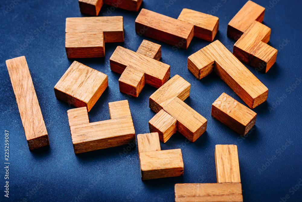 Different geometric shapes wooden blocks on a dark background. Creative, logical thinking and problem solving concept Different geometric shapes wooden blocks on a dark background. Creative, logical thinking and problem solving concept