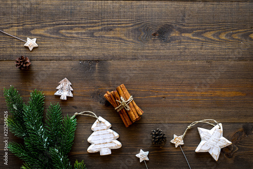 Christmas background. Spruce branch, cones and toys for decoration on dark wooden background top view copy space