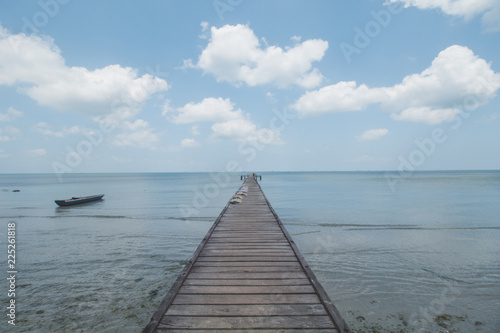 Wooden Dock, Clear Sea Water, Cloudy Sky and Tropical Beach