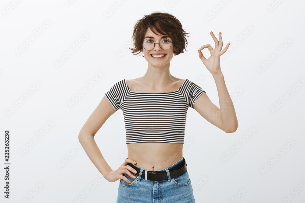 You are right, like your plan. Portrait of confident happy cutie in round glasses and trendy striped cropped top, showing okay or ok gesture and smiling broadly, giving positive feedback or agreeing You are right, like your plan. Portrait of confident happy cutie in round glasses and trendy striped cropped top, showing okay or ok gesture and smiling broadly, giving positive feedback or agreeing