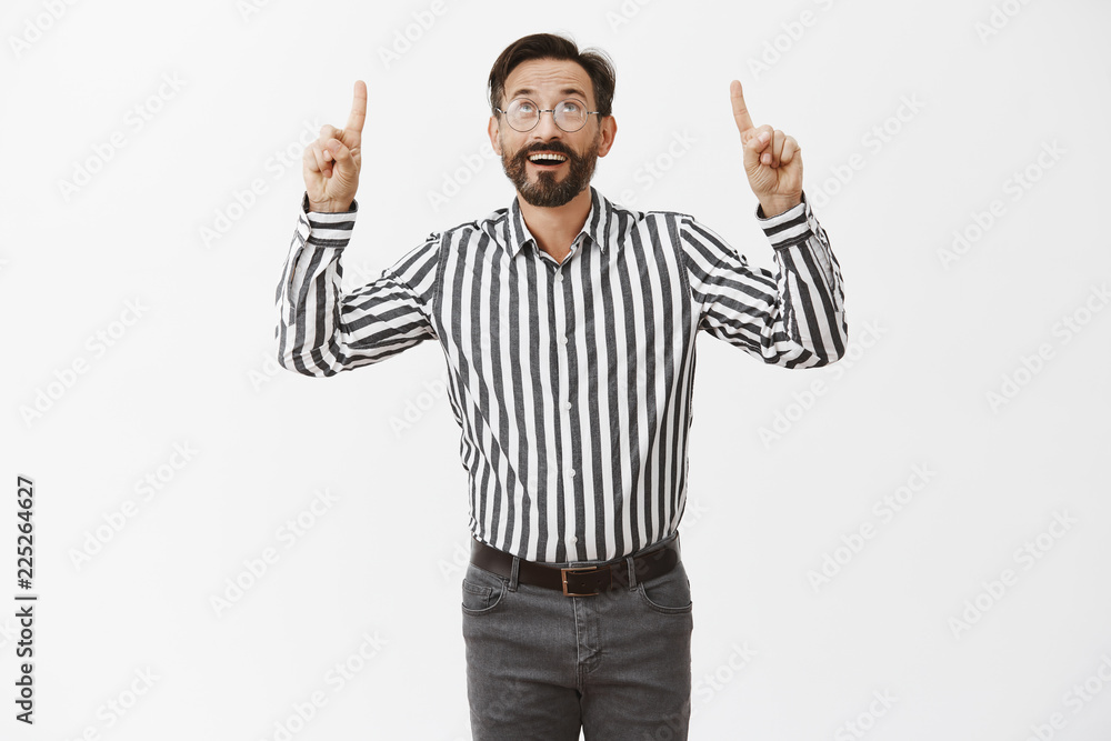 What beautiful day to make more money. Portrait of carefree joyful rich man with beard in fancy striped shirt and pants wearing trendy glasses, pointing and looking up in sky happily What beautiful day to make more money. Portrait of carefree joyful rich man with beard in fancy striped shirt and pants wearing trendy glasses, pointing and looking up in sky happily