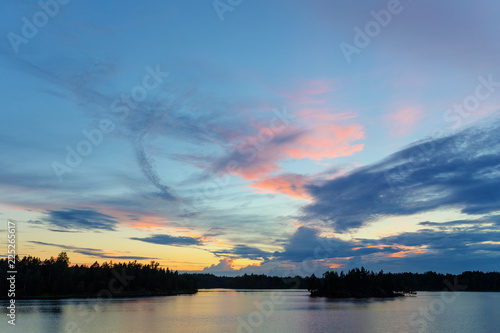 sunset with clouds over the forest lake