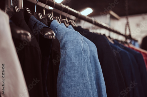 Photo of a rack with suit jackets in a menswear store.