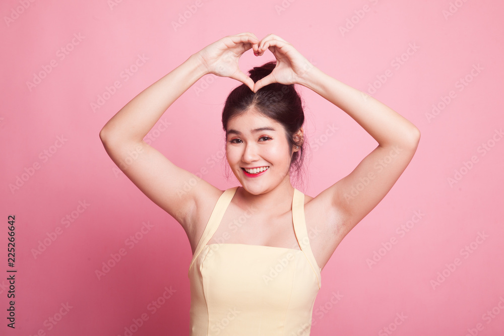 Young Asian woman gesturing heart hand sign. Young Asian woman gesturing heart hand sign.