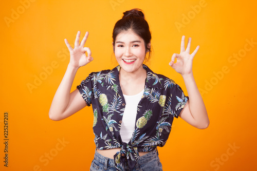 Asian woman show double OK hand sign  and smile in tropical shirt