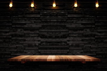 Empty brown plank wood shelf at black layer marble tile wall background,Mock up for display or montage of product or design