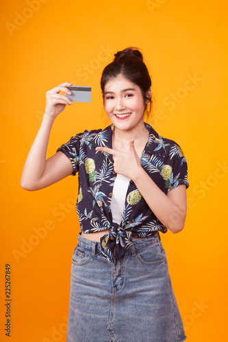 Young Asian woman point to a blank card in tropical shirt