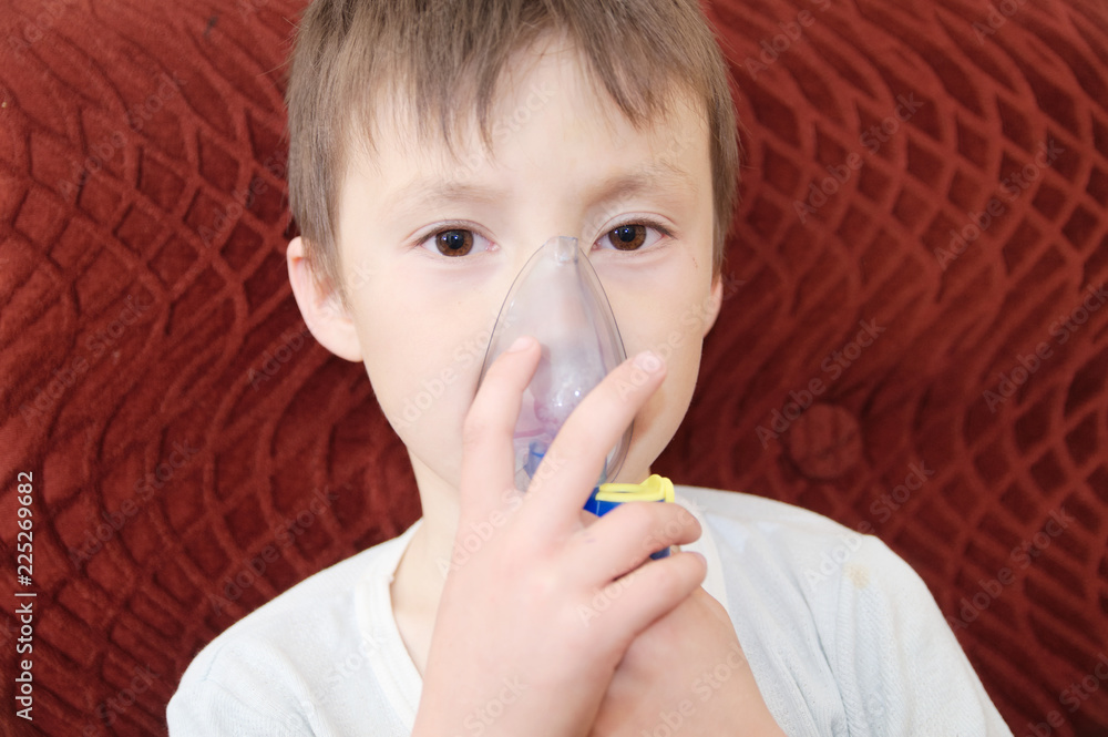 sick boy in nebulizer mask making inhalation, respiratory procedure by