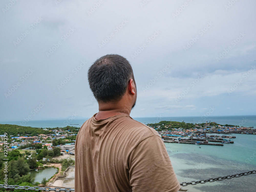 Asisn Fat Traveler stand on top of  Khao Ma Jor Pier  with Idyllic ocean beautiful white cloud endless horizon and Fishman townscape in vacation time,chonburi thailand,holiday concept