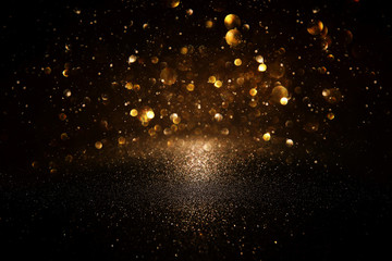 glitter vintage lights background. black and gold. de-focused.