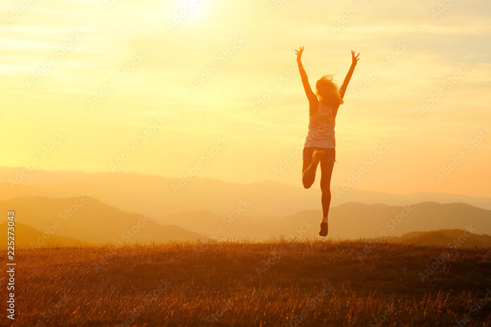 Happy woman with open arms stay on the peak of the mountain Happy woman with open arms stay on the peak of the mountain
