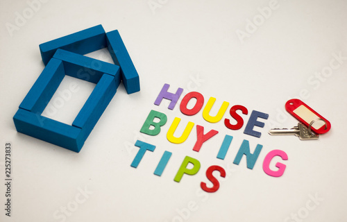 House model and wooden alphabet with text house buying tips