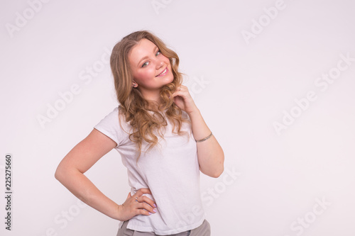 Young smiling woman posing over white background with copy space